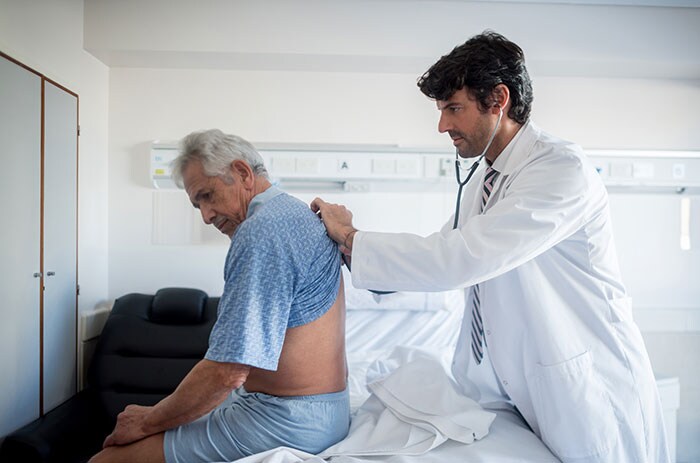 Un médico examinando un paciente mayor.