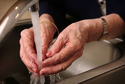 Elderly woman washing her hands