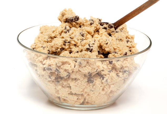 Bowl of cookie dough with a wooden spoon and chocolate chips