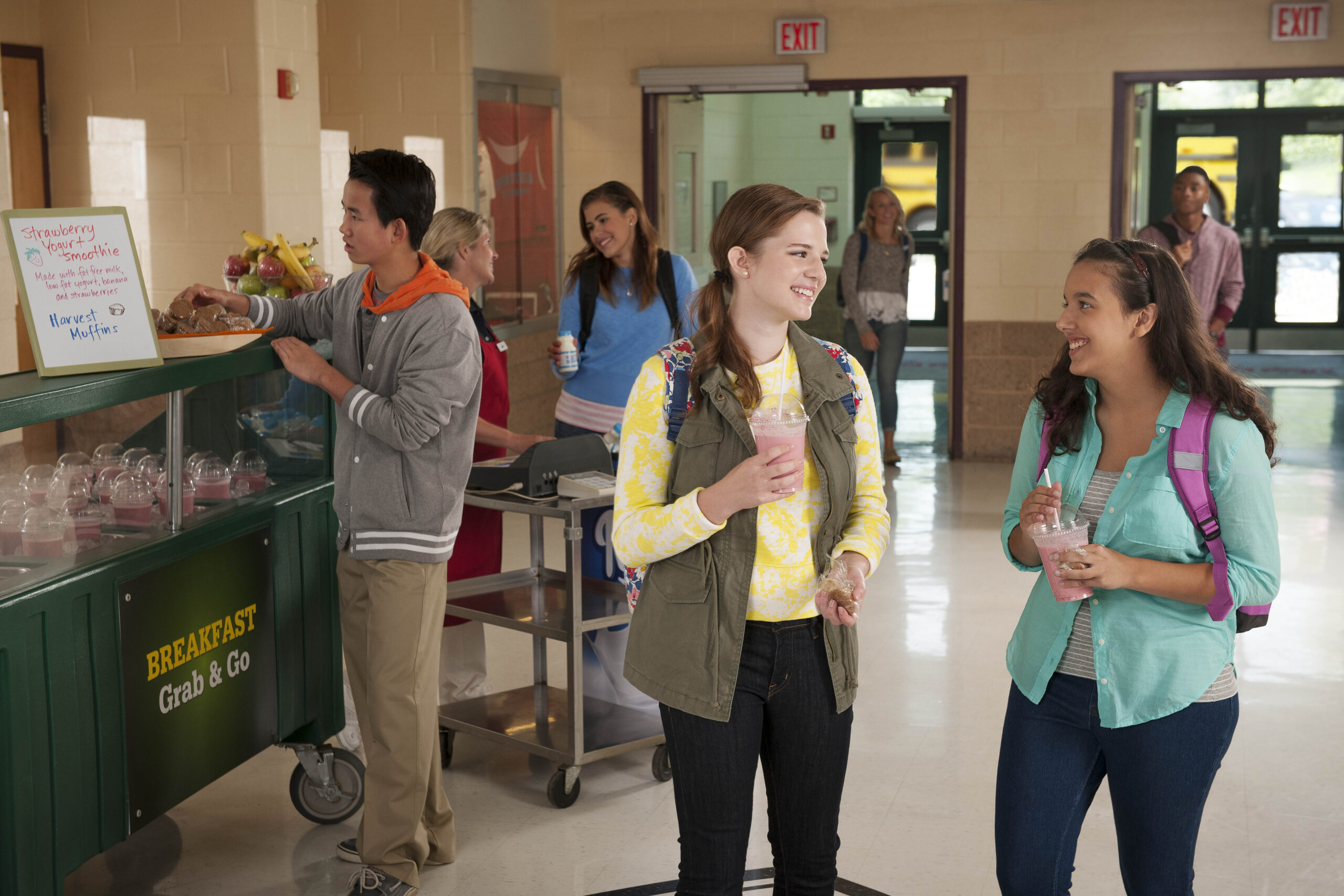 Students walking near breakfast grab & go counter at school.