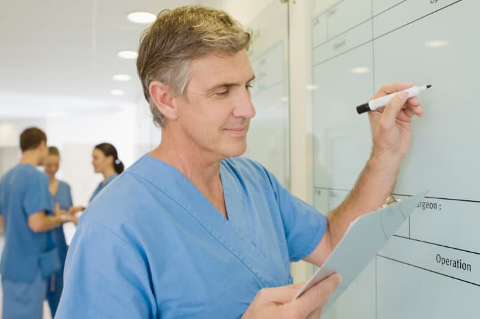 Photo of a clinic staff member writing on a white board