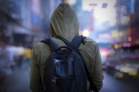 A person wearing a backpack and hoodie.