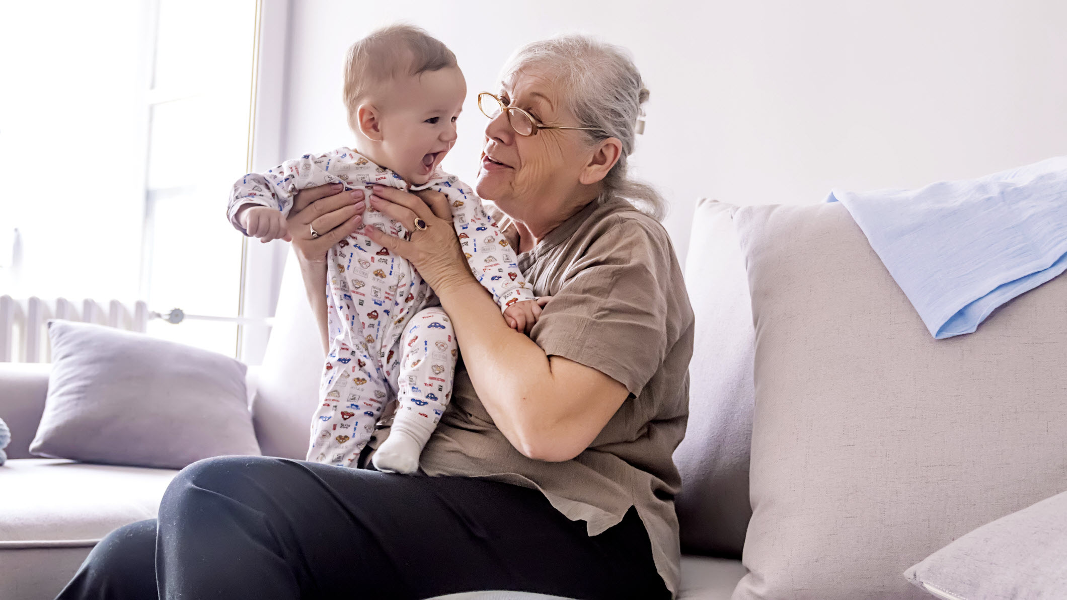 Grandma playing with grandchild on lap.