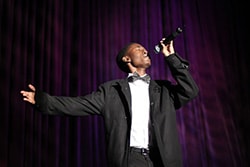 AJ Green wearing a tux and singing on stage