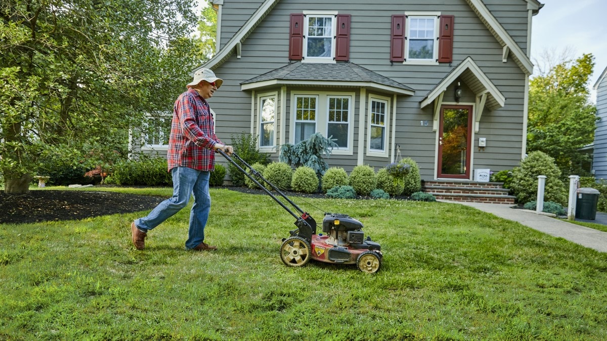 Photo of a man mowing his lawn