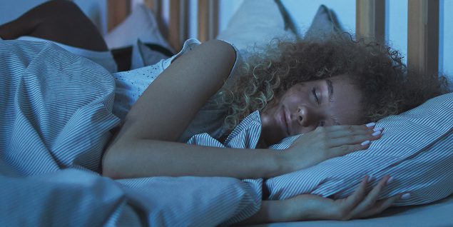 Woman in bed getting enough sleep, which is important for all people to stay healthy