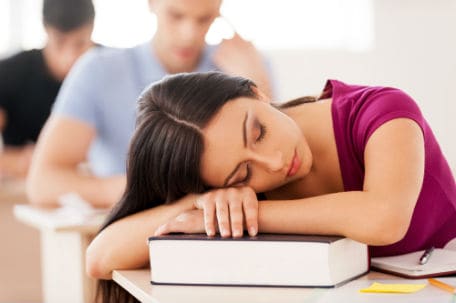 Photo of an adolescent girl asleep on her desk.