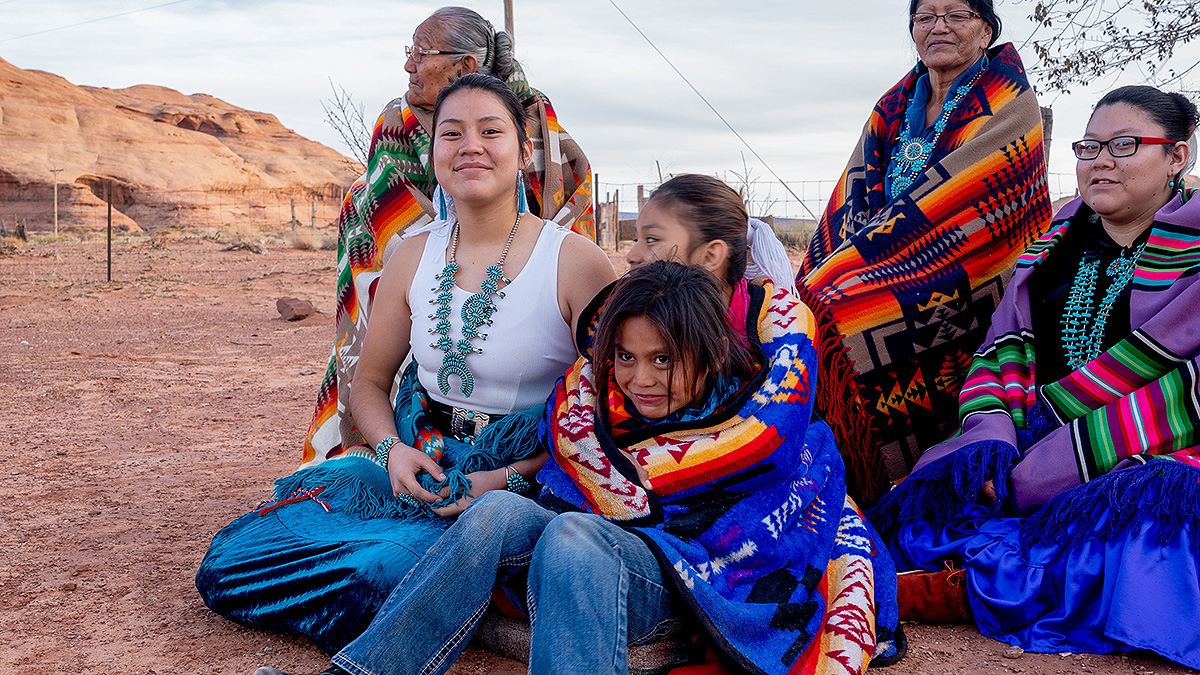 Multiple generations of female Navajos together, wrapped in customary blankets in Monument Valley.