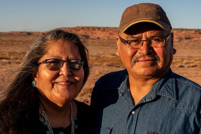 Foto de un esposo y una esposa nativos americanos cerca de su casa en Monument Valley, Utah.