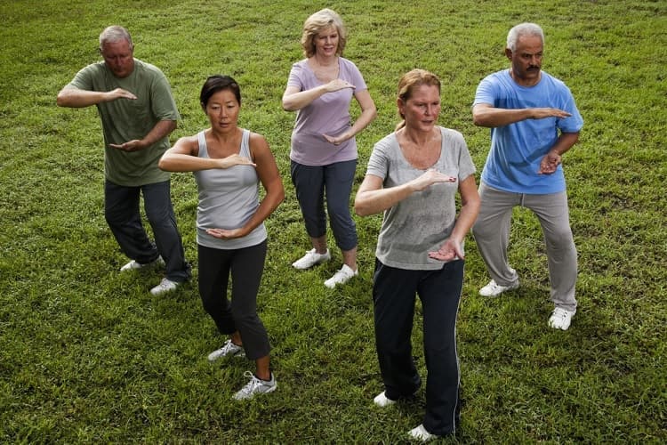 Photo of a group of men and women participating in a tai chi class
