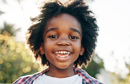 Un niño sonriendo y jugando al aire libre