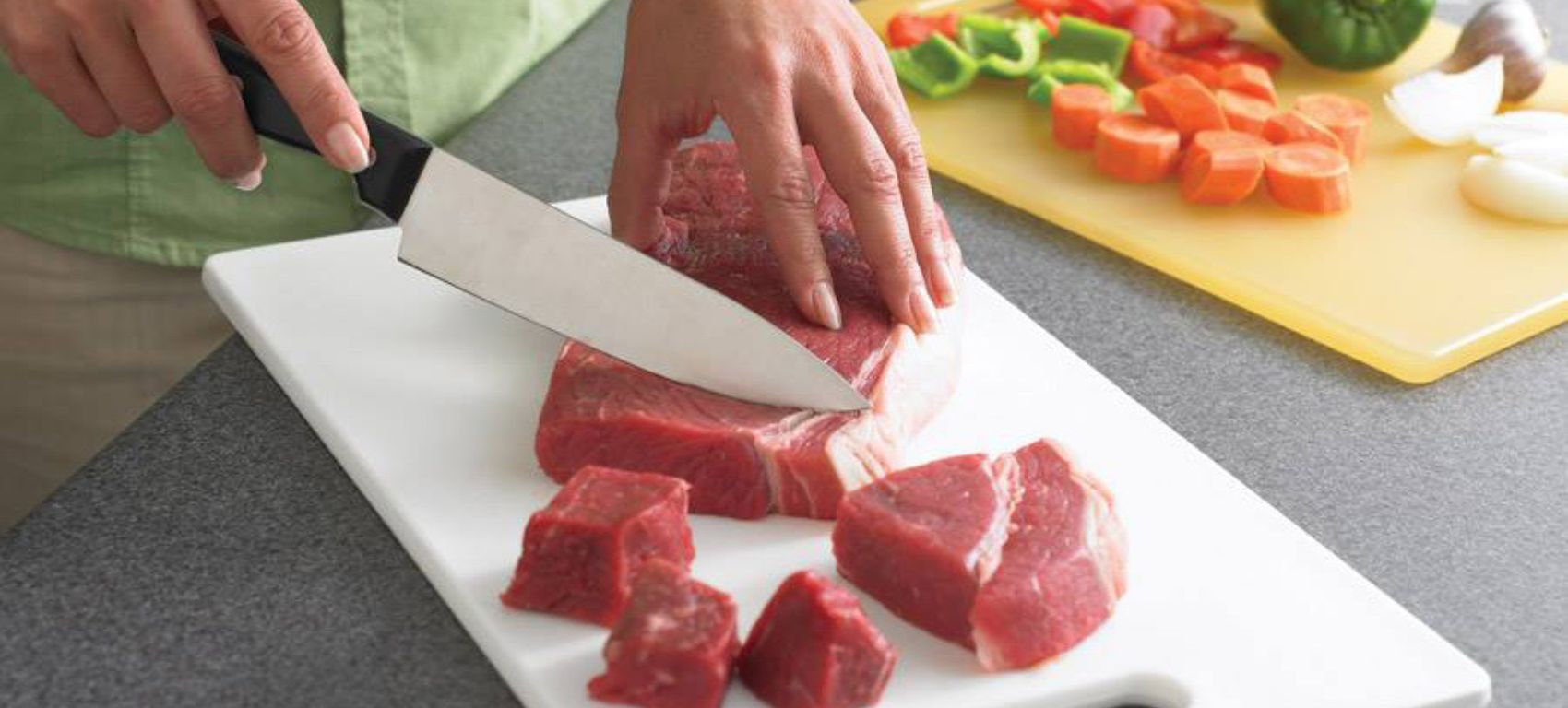Unas manos cortando un trozo de carne con un cuchillo