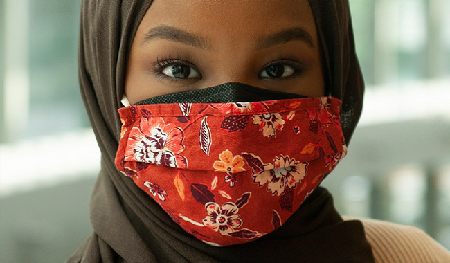 Una mujer con una mascarilla y un hijab.