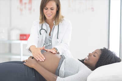 Una doctora examinando a una paciente embarazada