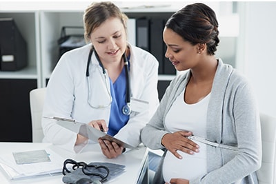 Doctora repasando resultados con una paciente embarazada
