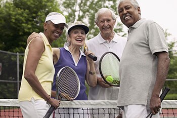 Grupo de parejas mayores jugando al tenis