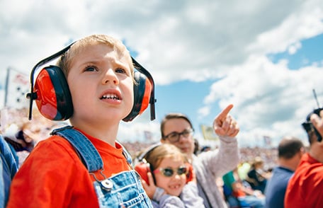 Un niño con protección auditiva en un espectáculo aéreo.