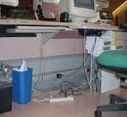 Estación de trabajo de computadoras con cables sobre el piso