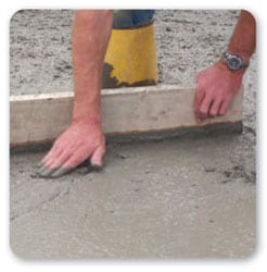 Vista de las manos de un trabajador aplicando cemento sin guantes protectores