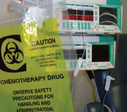 2013-103.jpg_c254e Recipiente para mezclar con controles de ingeniería (tapa de un tanque con bisagras y ventilación, con tapa de acceso). Trabajador con el equipo de protección personal apropiado puesto (respirador que cubre la cara completa con purificador de aire equipado con cartuchos para vapor orgánico P100, delantal y guantes).