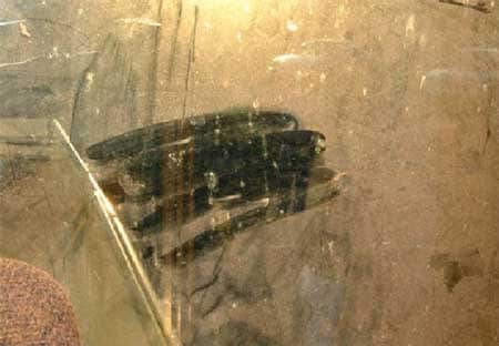 Foto 3: Esta foto muestra la vista a través de la ventana trasera desde el asiento del conductor de la motoniveladora. Parte del polvo se limpió, y si se mira cuidadosamente a través de la neblina, uno apenas puede ver a una persona parada a varios pies de distancia de la motoniveladora.