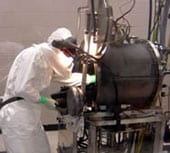Trabajador que quita nanotubos de carbono de un reactor del horno