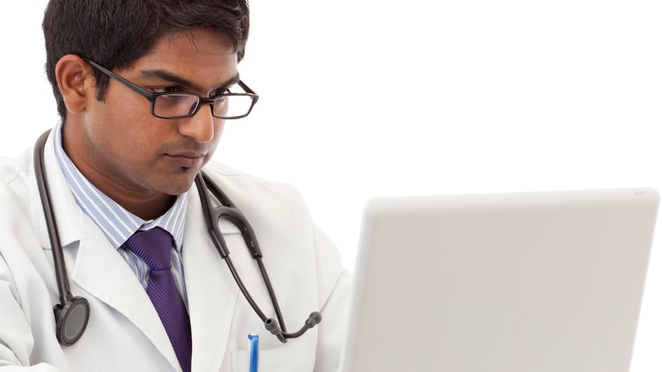 Healthcare provider with serious face working on laptop