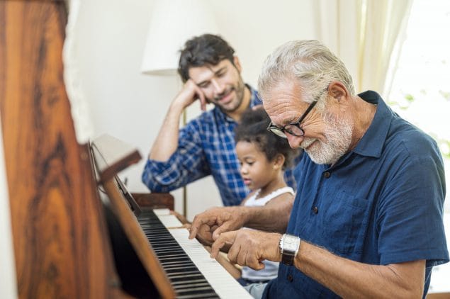Family spend time happy together. Grandfather playing piano