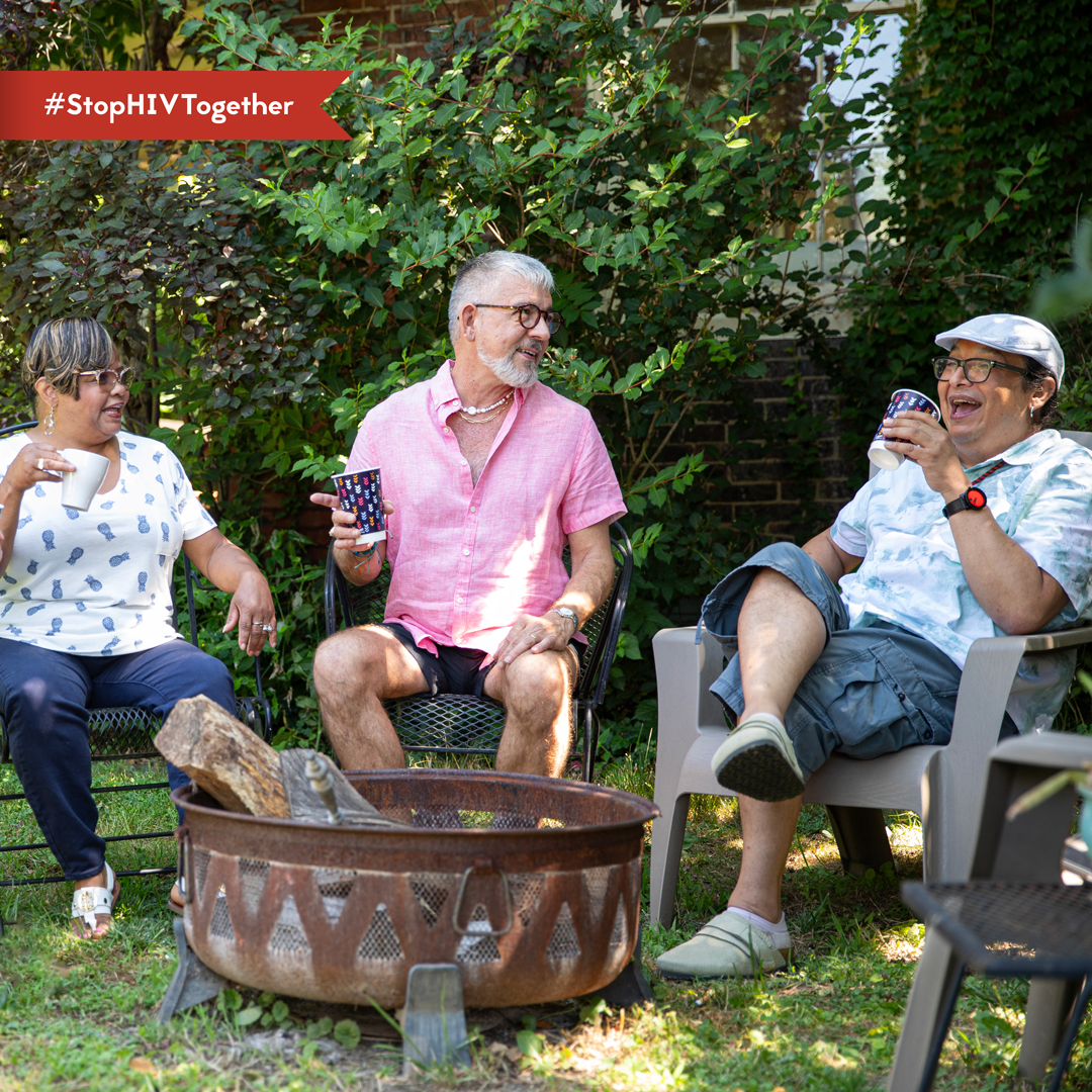 LGBTQ+ Pioneers An image of three older adults laughing together while sitting outside.