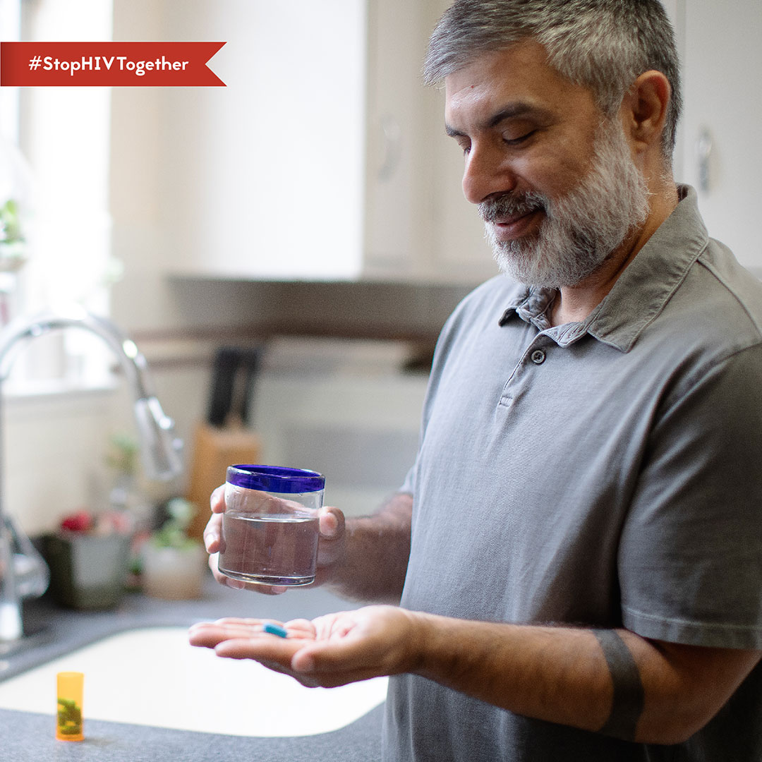 Healthy Aging – Javier An image of a man taking a pill with with a glass of water.