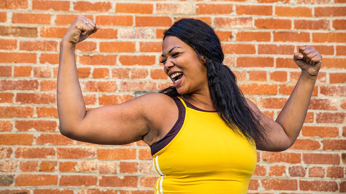 A Black woman showing off her strong arms.
