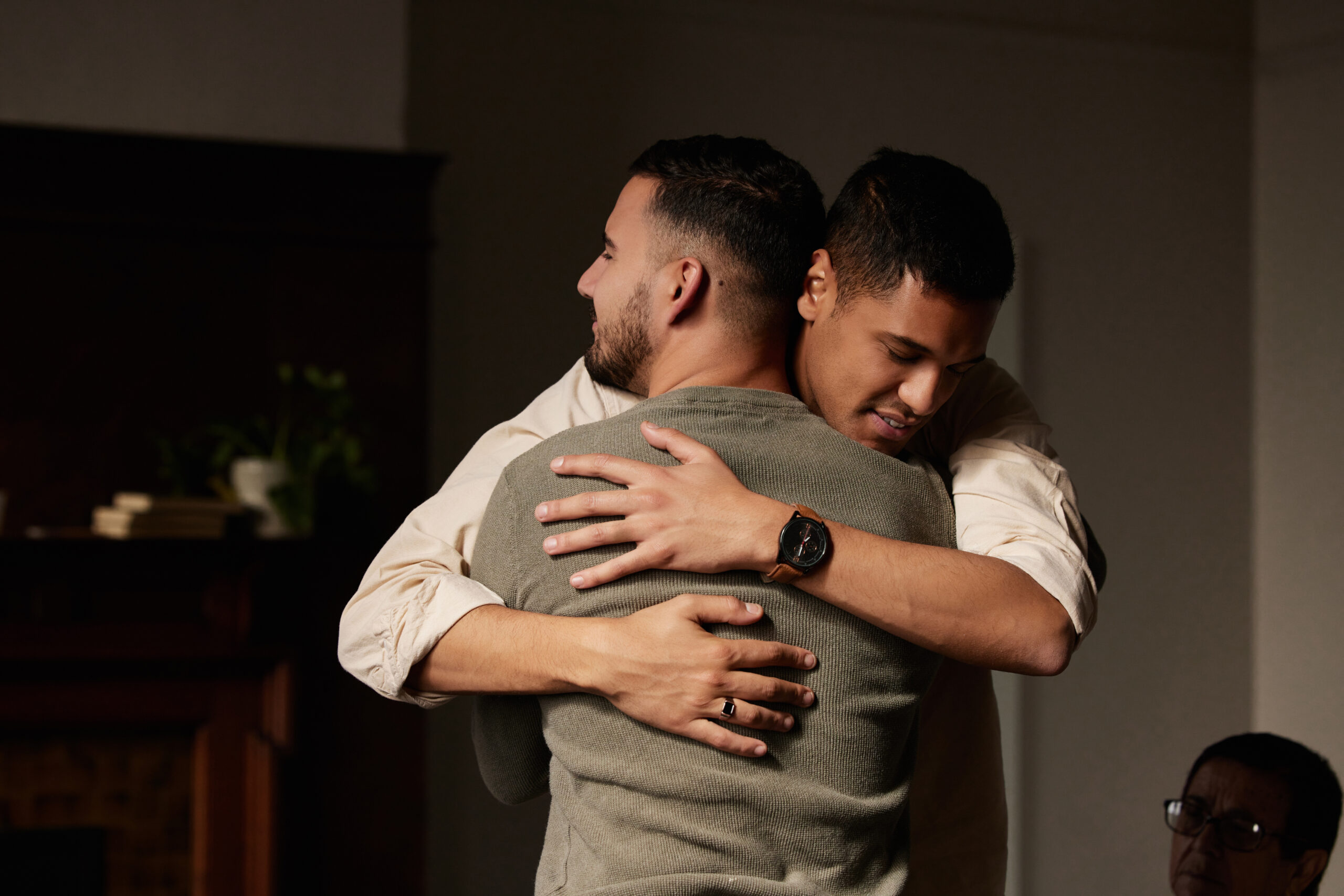 Two men hugging each other.