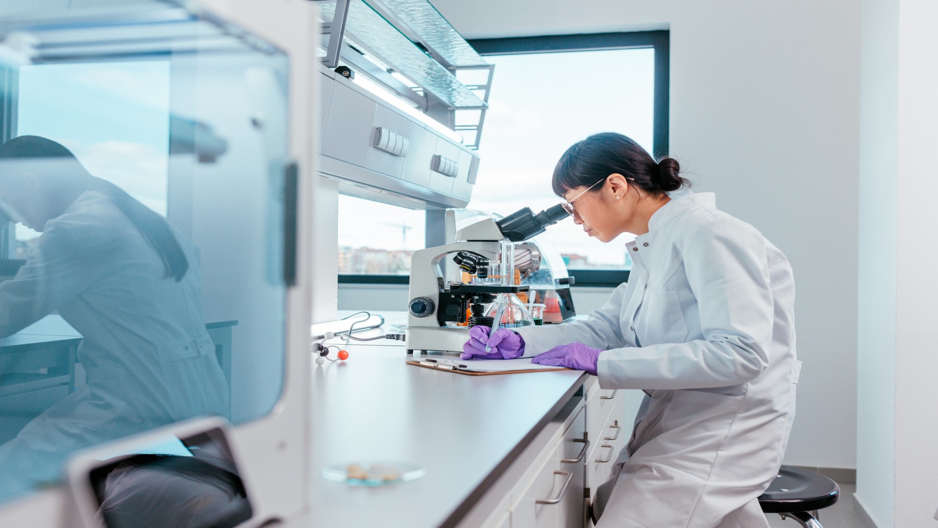Scientist looking into microscope