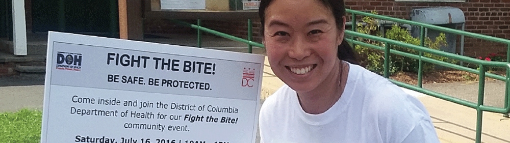 volunteer handing out free educational materials and Zika virus prevention kits