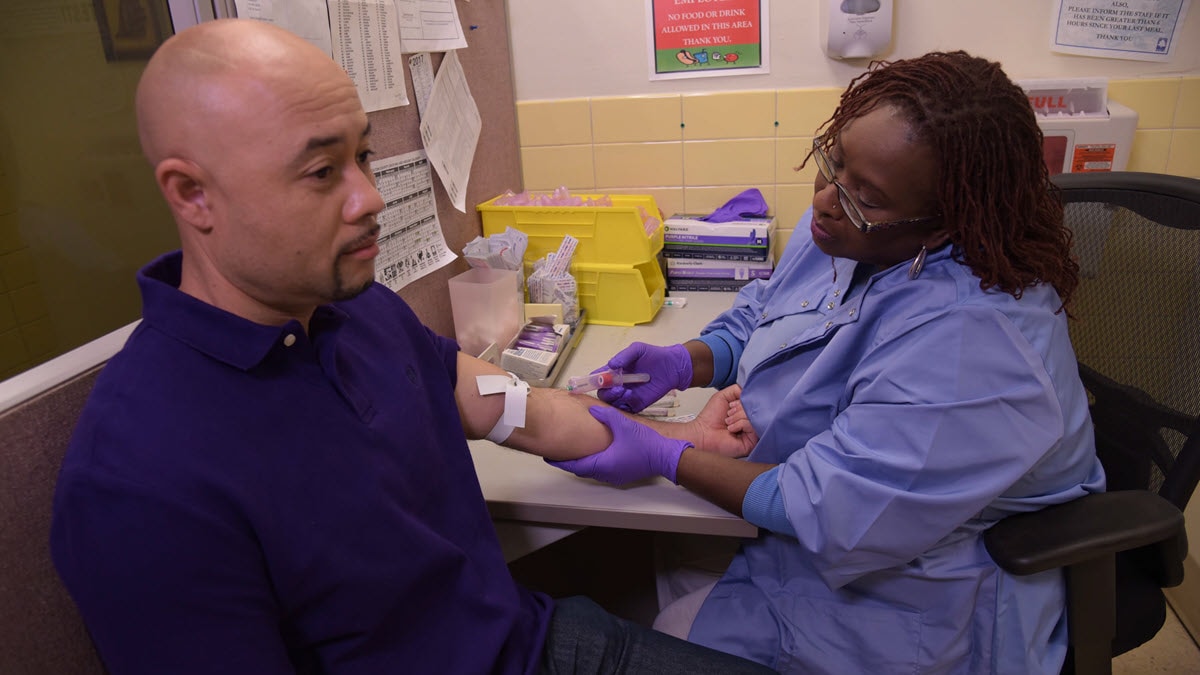 A health care provider performs a blood draw for a TB blood test on a patient.
