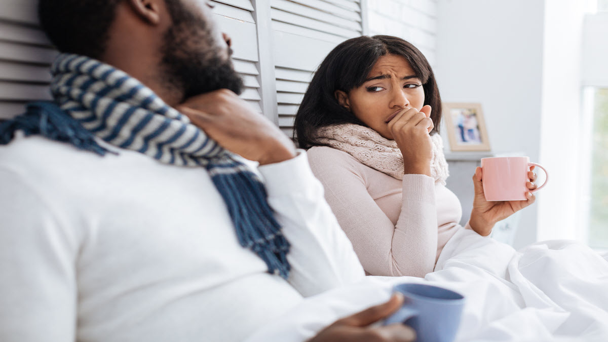 A woman coughs next to another person