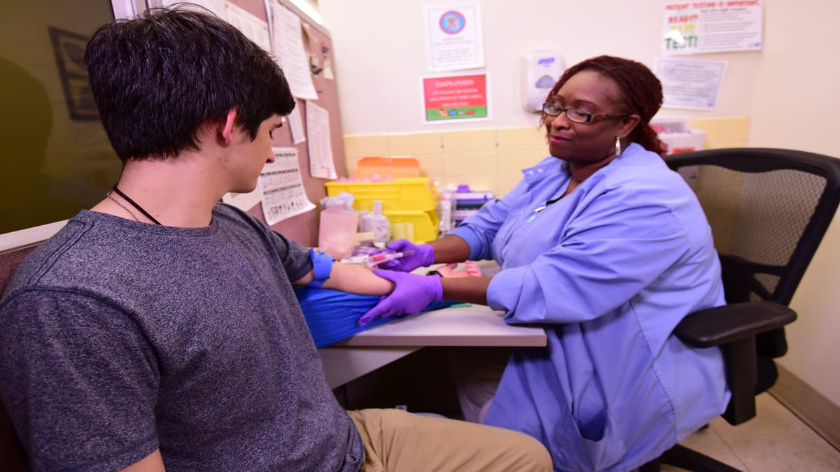 A provider draws a blood sample on a patient for a TB blood test