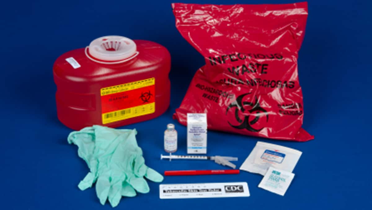 Supplies for administering and reading a TB skin test, including gloves, needle, tuberculin, sharps container, and ruler.