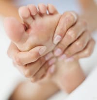 Mujer que se masajea el pie