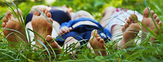 A family’s bare feet on grass