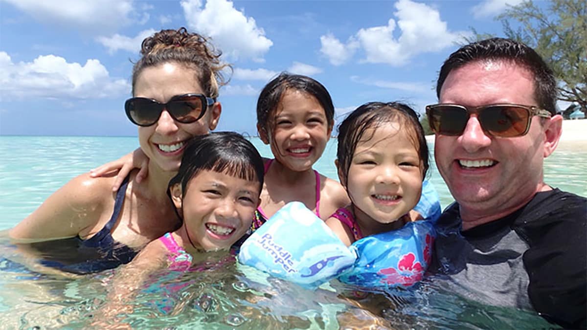 Photo of Tracy Antonelli, her husband and three children posing for a picture in the ocean.