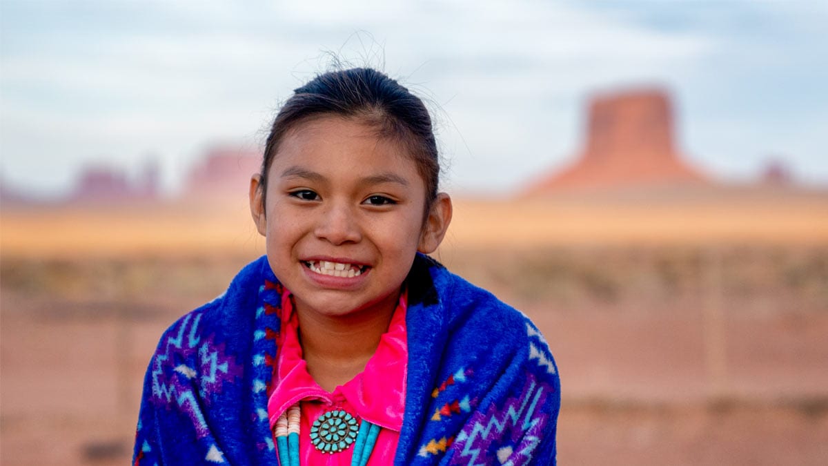 Young girl in front of desert background.