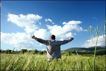 Man with arms outstretched in a field