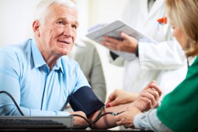 Imagen de un hombre mayor que le toma la presión arterial.