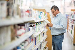 Man in pharmacy browsing quit smoking medications.