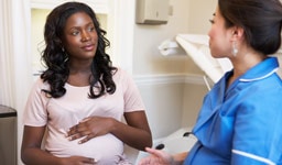 Mujer embarazada consultando a su médica