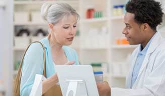 Farmacéutico ayudando a una mujer con un medicamento recetado