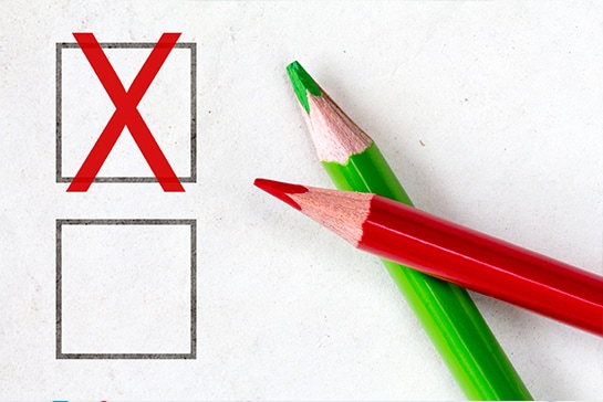 Colored pencils beside a checkbox with a red X