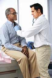Doctor using stethoscope on patient