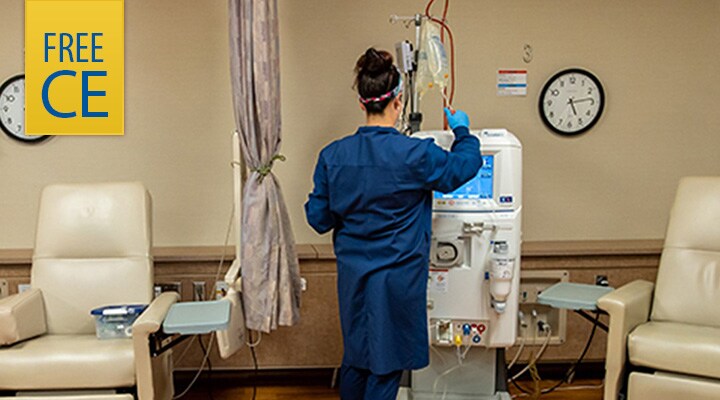 Healthcare worker facing a hemodialysis machine